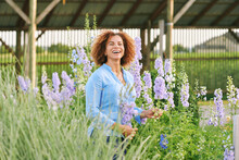 Outdoor Portrait Of Beautiful 50 Year Old Woman Enjoying Nice Day In Flower Park Or Garden, Happy And Healthy Lifestyle
