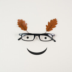 Wall Mural - Head with a smiling face, eyeglasses and foliage, mental health concept, positive mindset, support and evaluation symbol