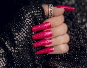 Wall Mural - Beautiful pink nail manicure. Holiday style bright manicure with glitter. Close up photo.