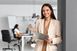 © Pixel-Shot - Smiling businesswoman with clipboard during meeting in office