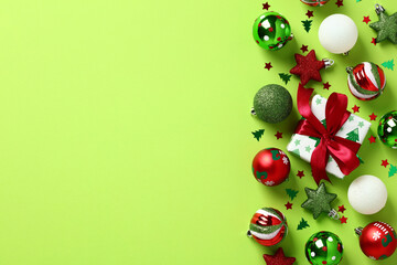 red and green christmas decorations on light green background. christmas frame. flat lay, top view, 