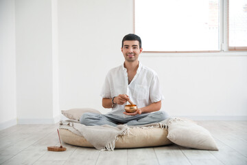 Poster - Young man with Tibetan singing bowl at home