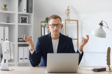 Poster - Young man meditating at table in office