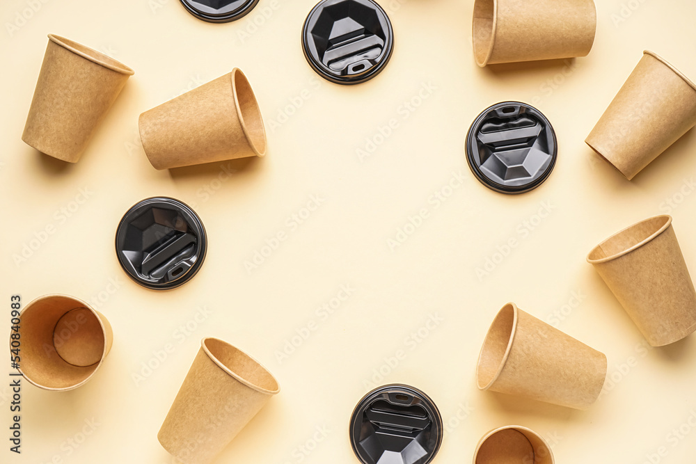 Frame made of paper cups and caps on color background