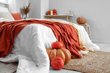 Fresh Pumpkins Near Bed In Light Bedroom