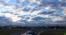 Timelapse Locking Of Clouds And Setting Sun Over A Busy Speedway Parking Lot - Daytona, Florida