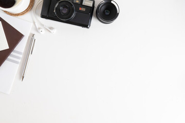 Wall Mural - Top view creative working desk with camera, book, coffee cup and stationery on white table.