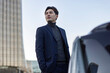 © Blue Jean Images - Businessman standing next to the car