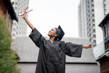 African people students man and woman with black graduation gowns hold the diploma and stand together. With the feeling of happy and graceful.