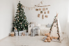 New Year 2023 American Interior. Children's Tent Decorated With Spruce Branches, Cozy Bed And Christmas Tree Decorated In Beige Natural Colors. Advent Calendar On The Wall. Selective Focus