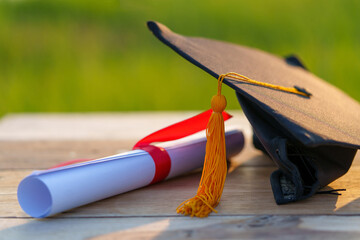 Wall Mural - A black graduation cap and a certificate placed on wood desk.