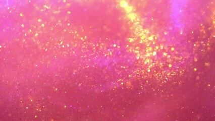 Wall Mural - Wavy movement of flying gold particles on a pink background. Chaotically moving gold shiny dust particles and bokeh. Beautiful abstract moving background.