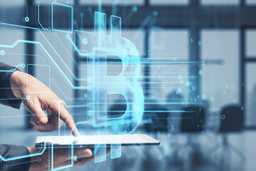 Poster - Close up of businessman hand pointing at tablet with glowing bitcoin hologram on blurry office interior background. Metaverse, cryptocurrency and crypto concept. Double exposure.