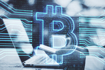 Leinwandbilder - Close up of hand using laptop keyboard and smartphone with creative bitcoin hologram on blurry desktop with coffee cup background. Cryptocurrency and blockchain concept. Double exposure.