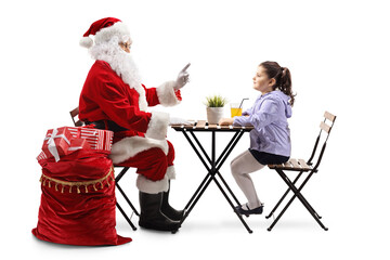 Canvas Print - Santa Claus talking to a little girl and sitting at a table