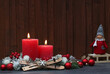 Arrangement mit roten Kerzen und Weihnachtskugeln mit Platz für Text.