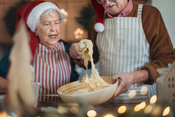 Wall Mural - Happy seniors baking a Christmas cakes together.