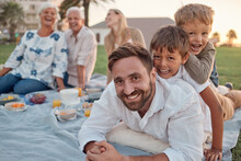 Family Picnic In Garden, Father With Kids In Outdoor Park And Healthy Food For Snack With Grandparents Support. Children Playing With Dad On Grass, Parents On Weekend And Big Family Vacation Together