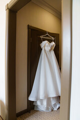 Wall Mural - Classic simple white wedding dress on the door.