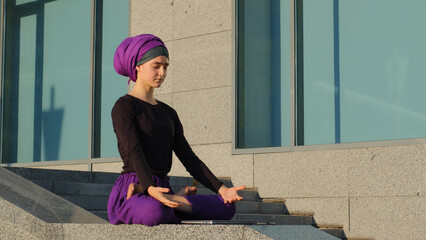 Tired worried overworked islamic girl muslim student business woman sit in city working studying at laptop feels angry turns off computer sits in lotus position meditating feeling calm meditation