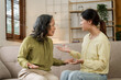 © NanSan - Asian mature mom and adult daughter have fight at home while sitting on sofa.