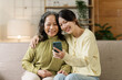 © NanSan - Mature asian mom with daughter on video call to parents, loving mother day concept.