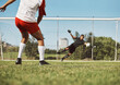 Sports man, soccer training and goal kick by soccer player on a soccer field with goalkeeper, energy and power. Football player, football and target practice professional athlete in performance game