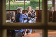 © Cavan Images - Female caretaker feeds feeble elderly man on screened porch
