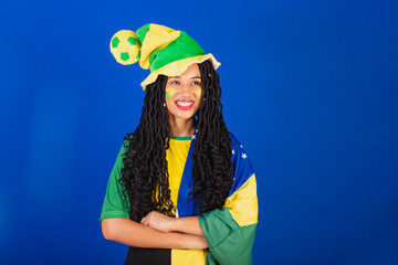 Young black Brazilian woman, soccer fan. wearing flag, hands on hips.