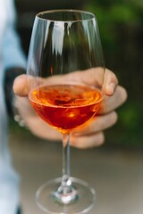 Sticker - Vertical closeup of a glass of wine in a hand