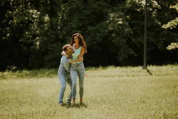 Wall Mural - Happy young couple in love at the grass field