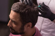 Mesotherapy for hair. Attractive man receiving injections in his head. Man having mesotherapy session at beauty salon, therapist in protective glove with syringe,