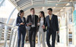 © Naypong Studio - Business people walking and talk to each other in front of modern office