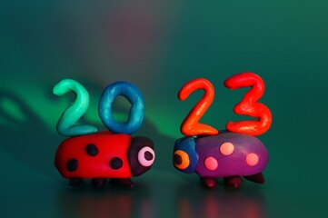 Canvas Print - Two ladybugs and the number 2023 on a green background. Holiday date. New Year and Christmas.