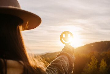 Side view of young female holding happy smile face on background amazing sunset in mountains at autumn calm day, good feedback rating and positive customer review, satisfaction survey, mental health