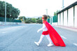© ADDICTIVE STOCK - Boy in superhero costume walking on street