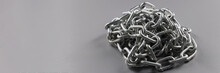 Grey Solid Chain Folded In Heap, Steel Metal Iron Chain On Grey Surface