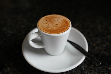 Wall Mural - Closeup of an espresso coffee on a black table