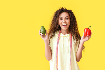 Poster - Happy young African-American woman with measuring tape and healthy food on yellow background. Diet concept