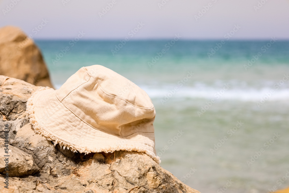 Stylish bucket hat on rock near sea, closeup