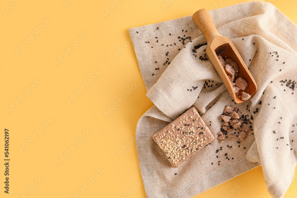 Napkin with sweet sesame halva on color background