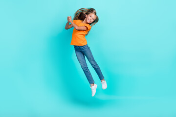 Sticker - Full body size photo of cute little pretty schoolgirl wear orange t-shirt jumping air trampoline new sneakers shopping carefree isolated on cyan color background