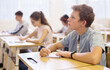 © JackF - Portrait of diligent teenager schoolboy sitting in class working with classmates
