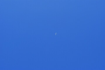 white plane flying against a clear blue sky.