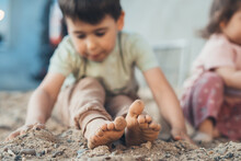Cute Boy Getting Dirty While Digging In Sand, Playing With His Sister In Backyard Home Garden On Nature. Two Funny Little Kids. Messy Games Outdoors.