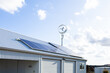 © Austockphoto - Off grid sustainable living with wind turbine power generator and solar panels on shed roof