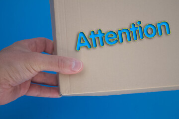 Poster - Attention word with cardboard box. Brown folded card box.