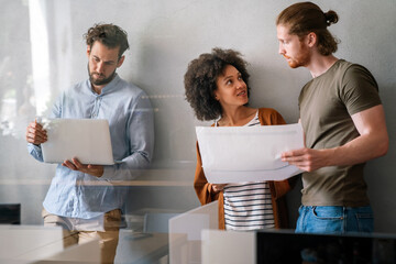 Group of young happy creative team, multicultural coworkers working in office together