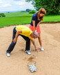 © ARochau - Golftrainer beim Üben im Sandbunker mit einer Golferspielerin