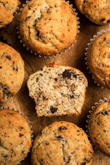 Wall Mural - Chocolate banana muffins on a wooden board, top view